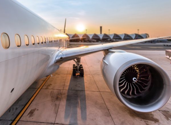 View from front of plane on tarmac of plane wing and engine