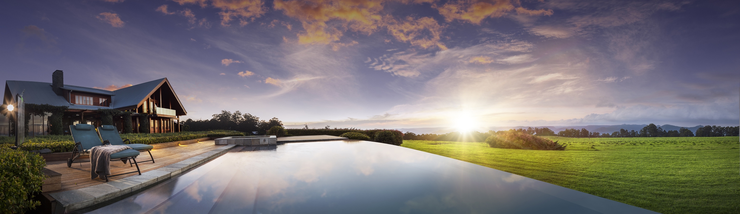 View of pool with lodge and sunset in the background